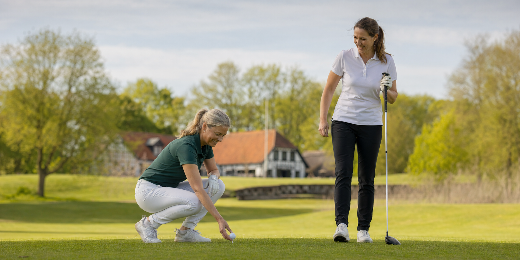 To kvinder gør sig klar til at slå ud på en golfbane.